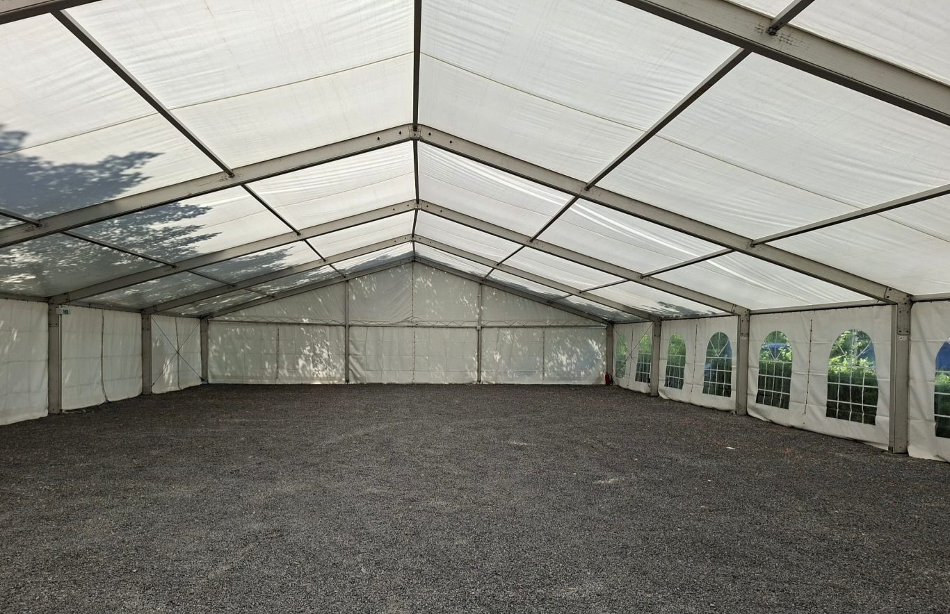 Großer leerer Zelt-Innenraum Großer, leerer Zelt-Innenraum mit weißen Wänden und grauem Boden.