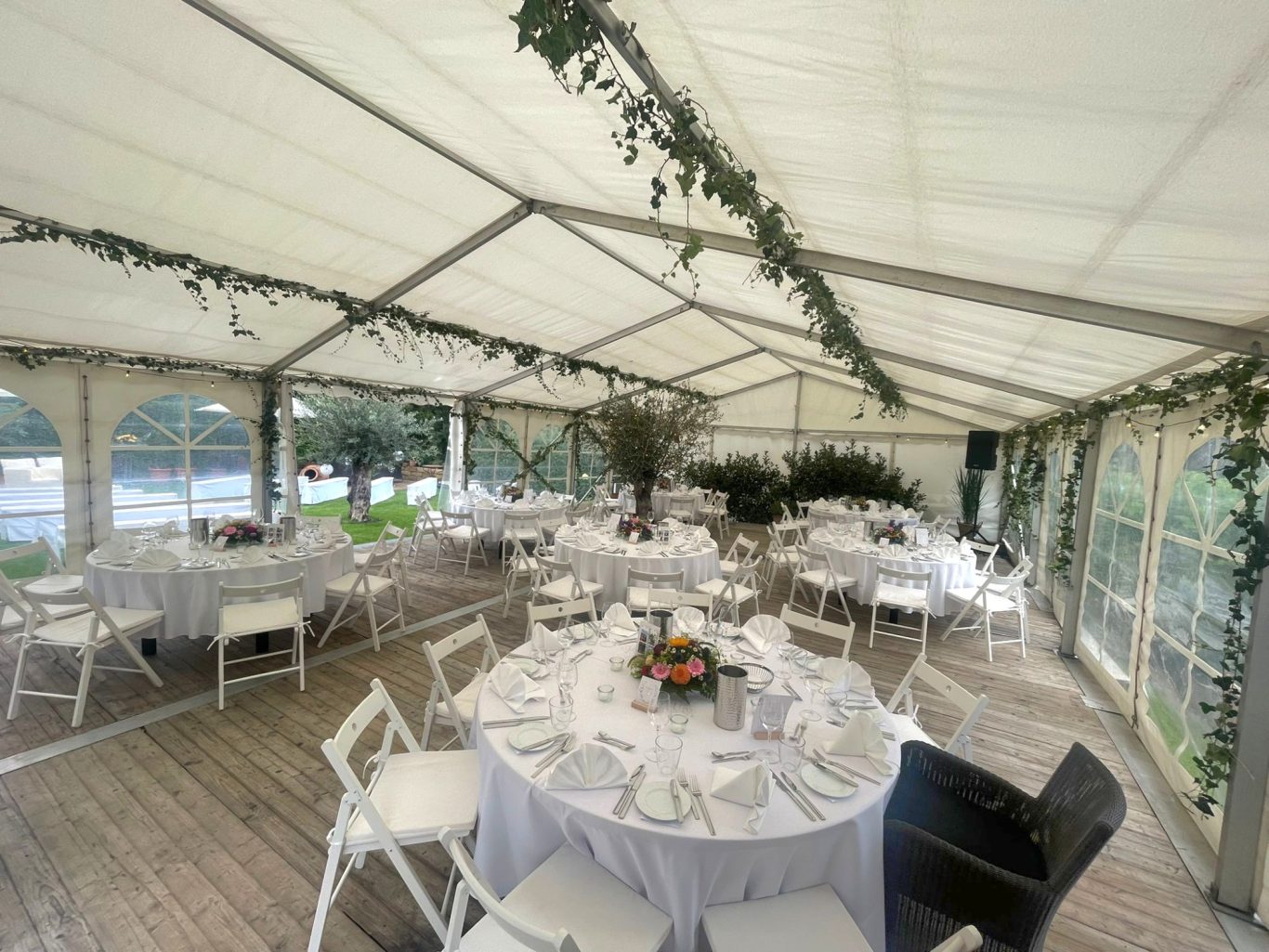 Innenbereich Hochzeitszelt Festlich dekorierter Veranstaltungsraum mit runden Tischen und eleganter Tischwäsche.