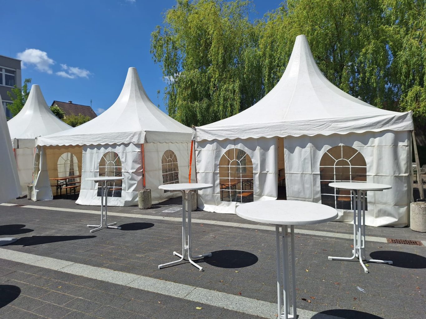 Mehrere Pagodenzelte für Veranstaltung Zwei große, weiße Zelte mit runden Fenstern und Stehtischen auf einem Platz.