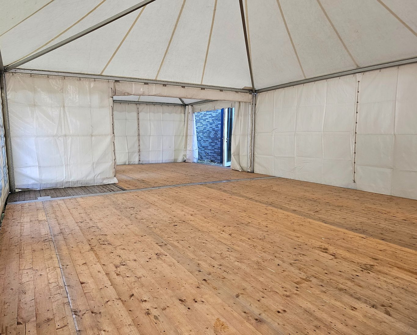 Innenansicht Pagoden mit Zelt Innenansicht eines leeren Zeltes mit Holzboden und offenen Seiteneingängen.