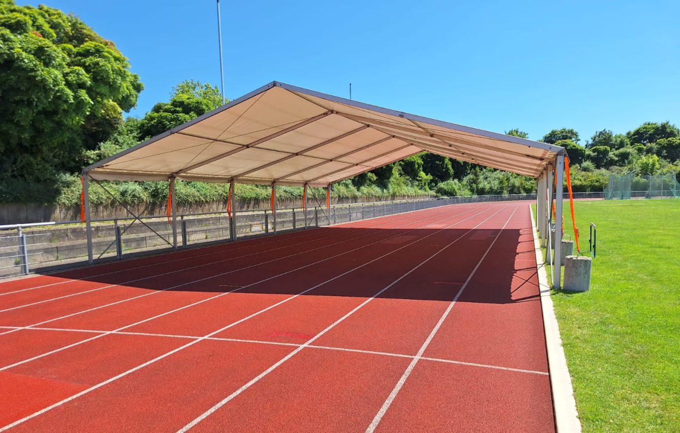 Sportplatz mit überdachtem Bereich Sportplatz mit rotem Laufbahn und einem überdachten Bereich auf der linken Seite.