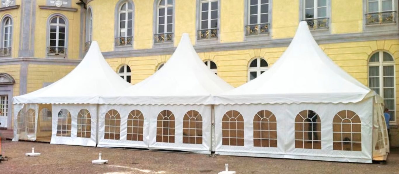 Drei Pagodenzelte vor Schloss Karlsruhe Weißes Festzelt mit spitzen Dächern und Fenstern, auf festlichem Gelände aufgestellt.