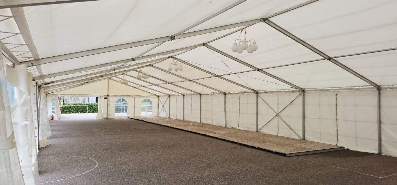 10m Zelt Innenansicht auf Schulhof Leere Zelt-Innenansicht mit Holzboden und weißen Wänden.